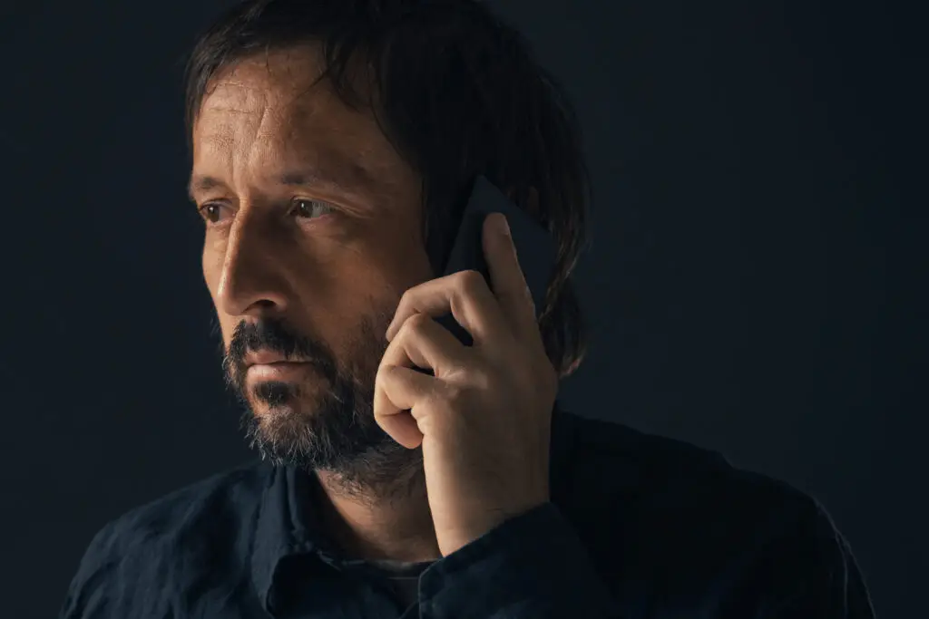 man on the phone in a darkened room
