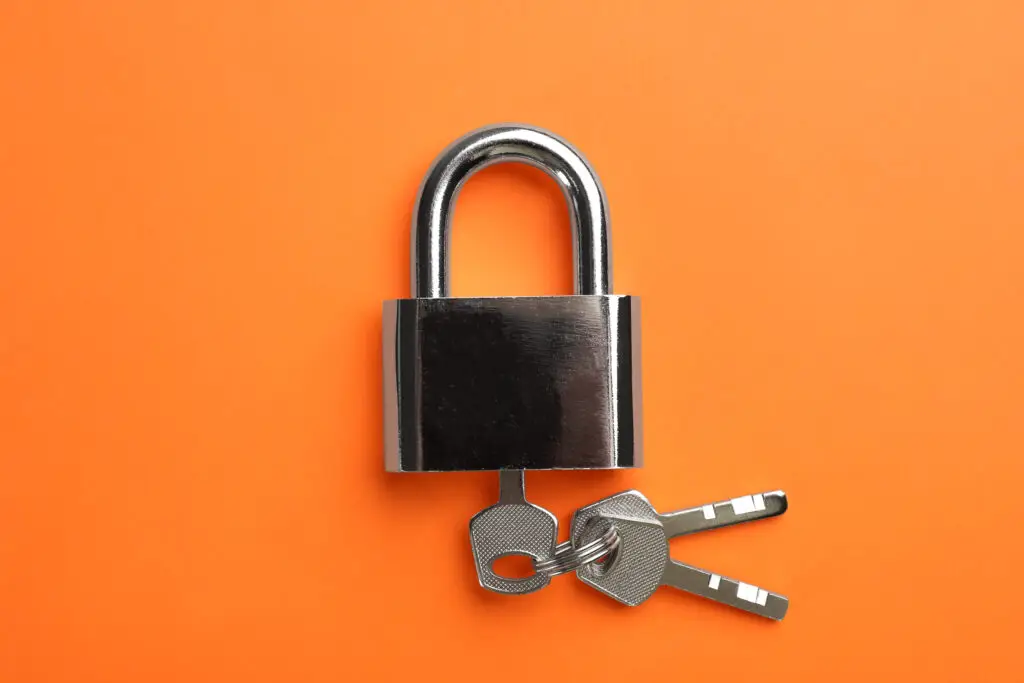 Padlock with keys on orange background