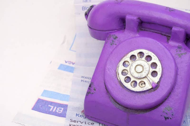 a tatty looking phone with mounting bills